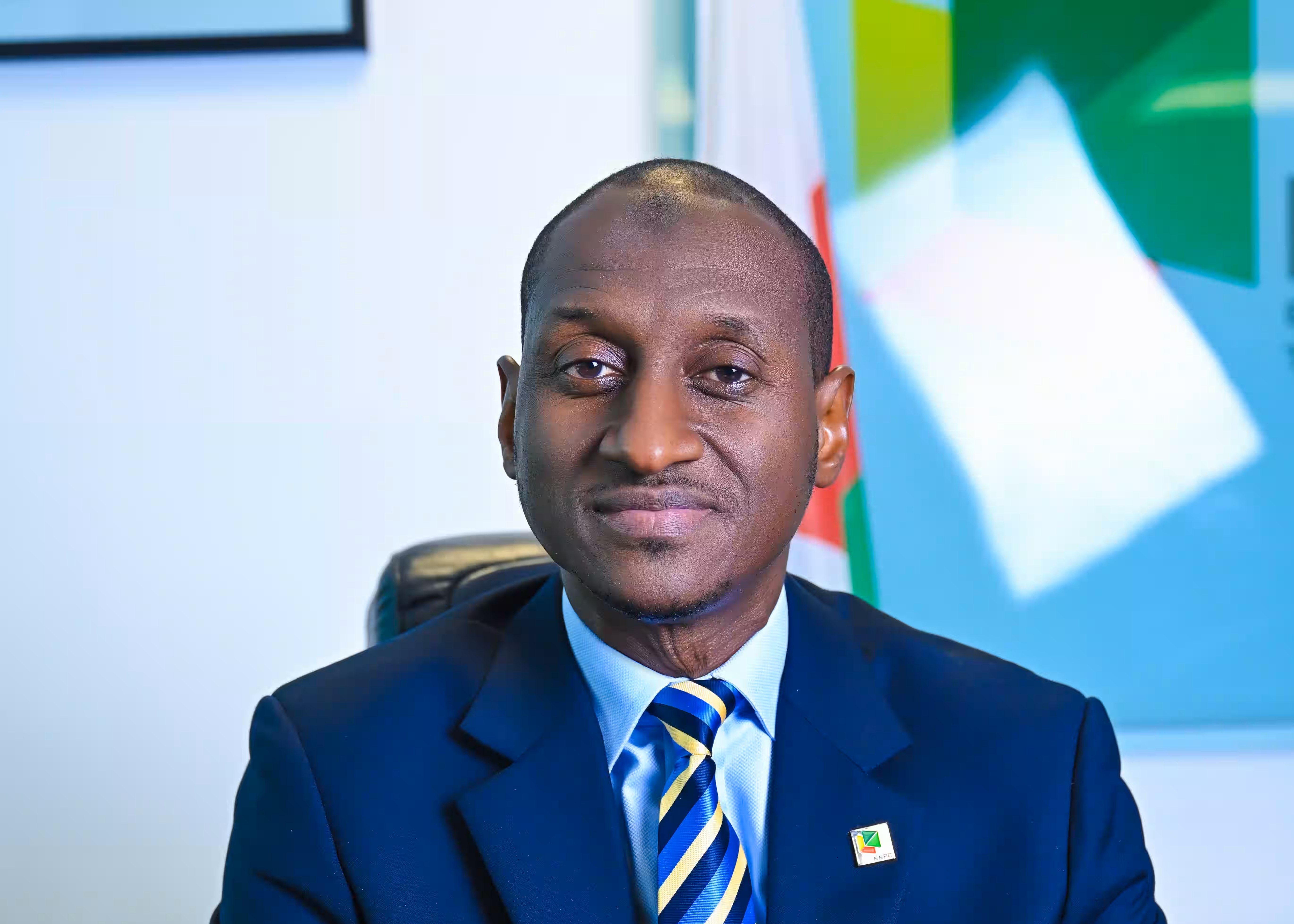 MD sitting down in his office with the NNPC log as background